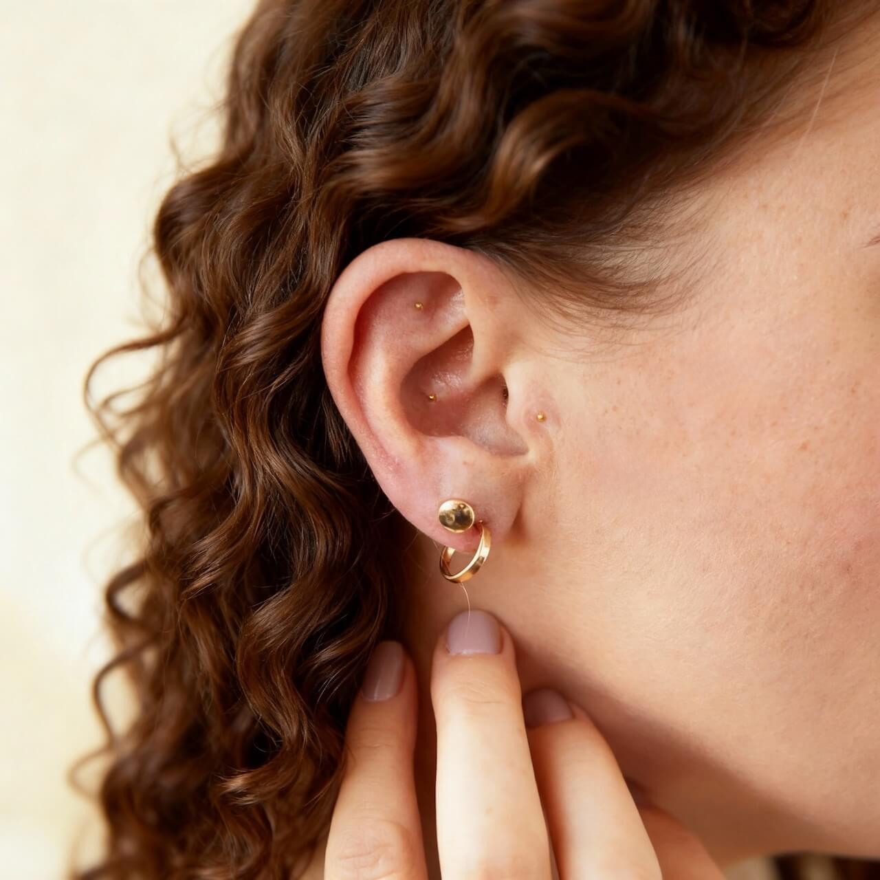 Picture of a woman's ear with ear seeds applied