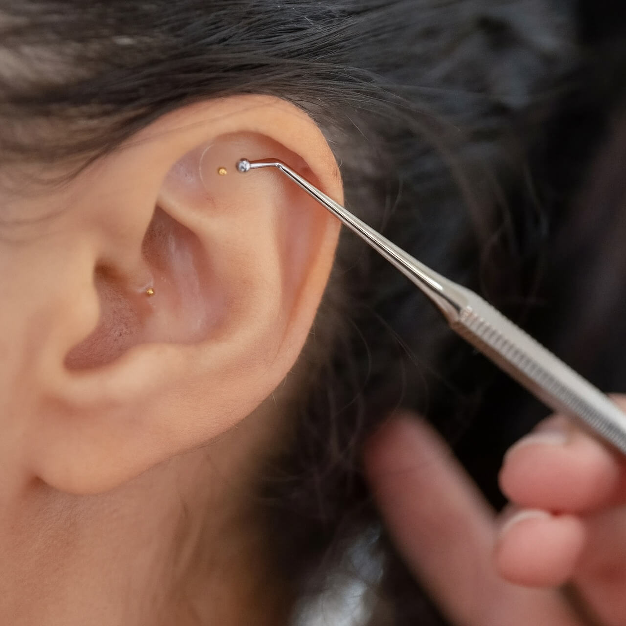 Picture of a woman's ear with ear seeds applied