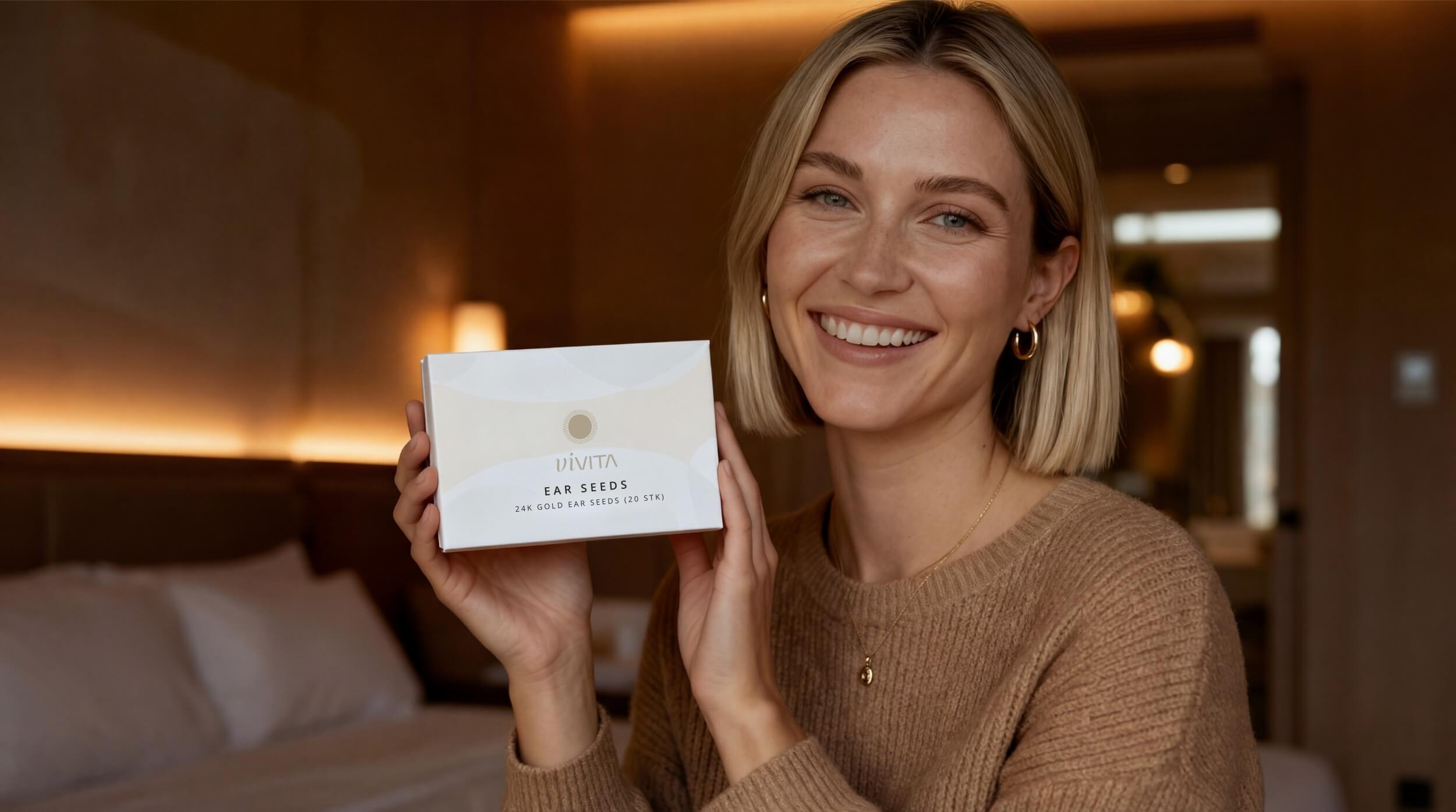 Smiling woman holding Vivita Ear Seeds box